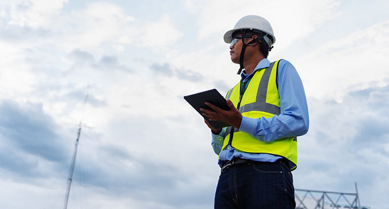 Engineering Consulting on construction site holding tablet in his hand