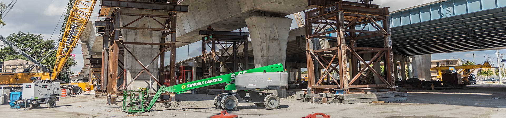 Miami, Florida, USA - February 8, 2022: Heavy machinery and workers working on the construction of a new viaduct (I-395/SR 836/I-95 Project) along the north of downtown Miami, where new luxury housing complexes are being developed.