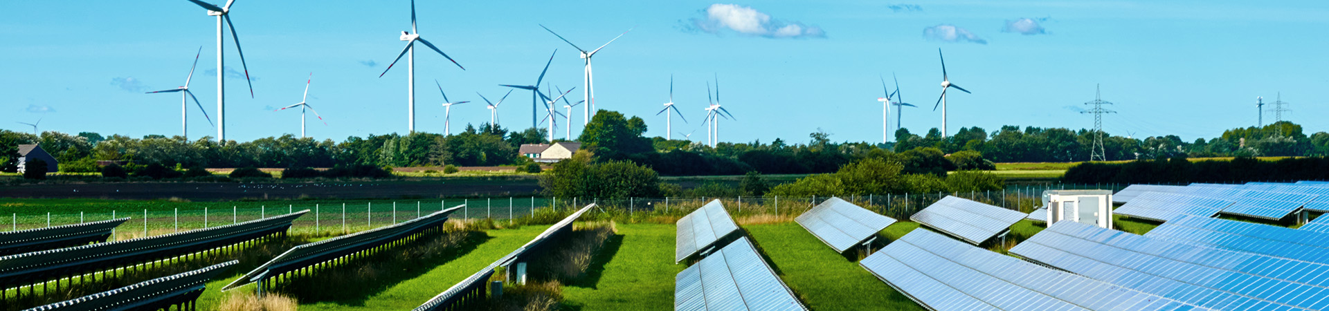 Solar panels and wind-powered generators on a green field